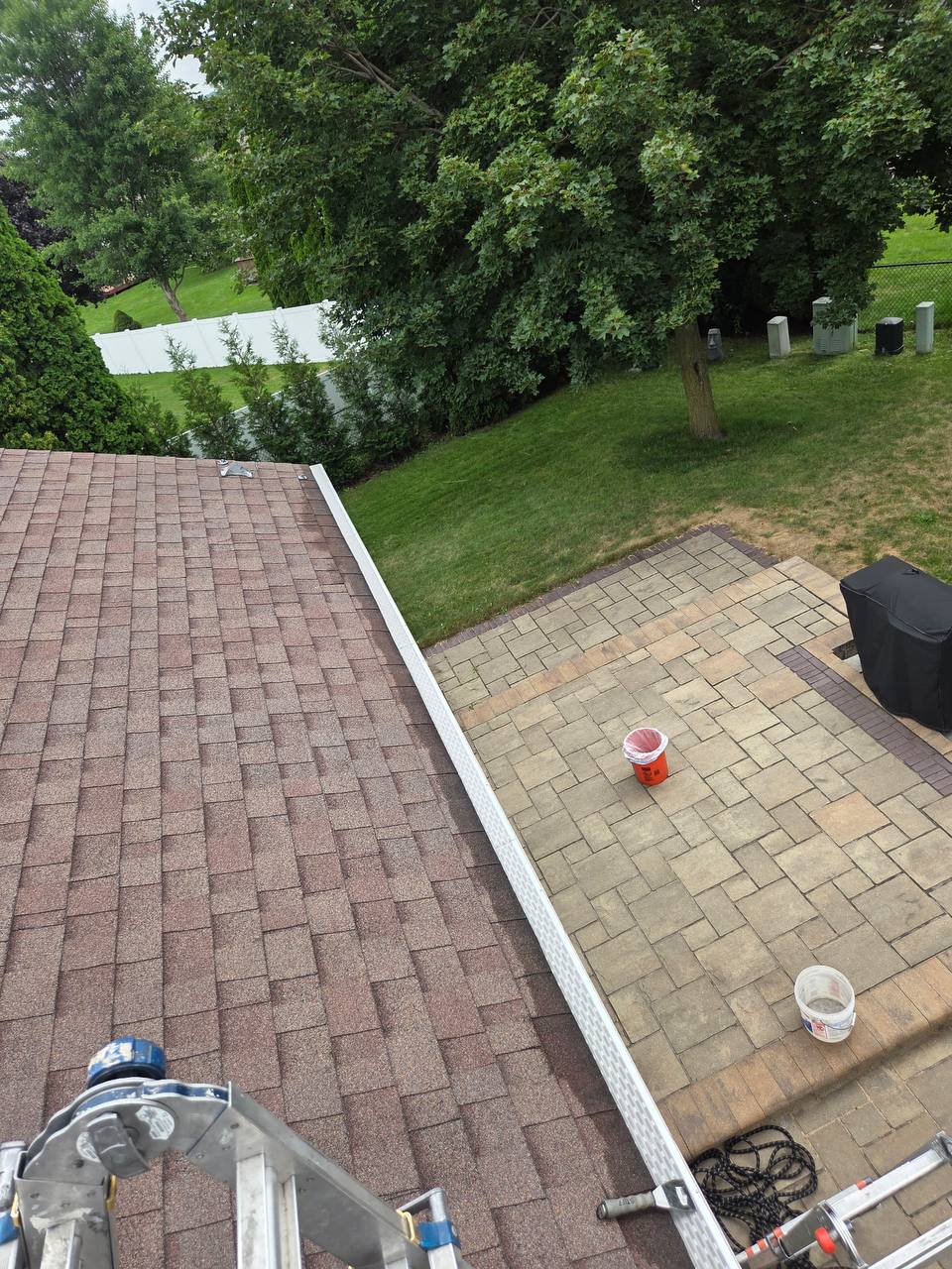 Finished white micro-mesh gutter guard viewed above a residential patio