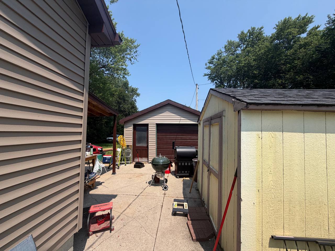 After driveway photo showing finished siding and exterior trim near garage and gutter area