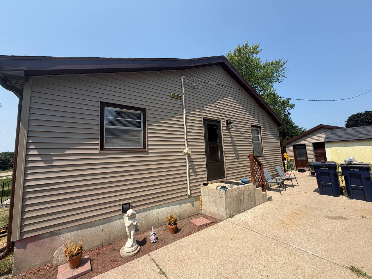 After side photo showing clean tan siding with finished fascia and gutters